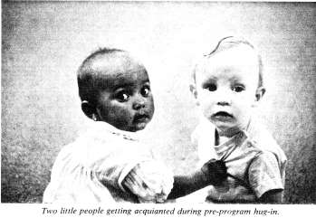 Two little people getting acquianted during pre-program hug in