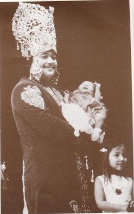 Prem Rawat aka Maharaji on stage dressed as the God Krishna with his children